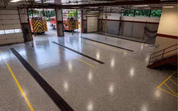 Fire station apparatus bay with flake epoxy floor coating and fire engine